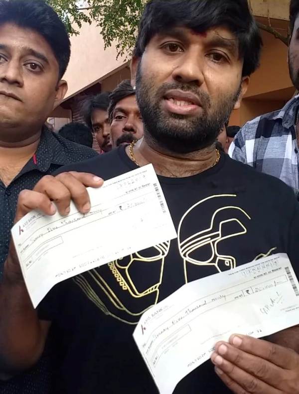 Cool Suresh while holding cheques that he donated to the families of deceased Army soldiers in Tamil Nadu in 2019