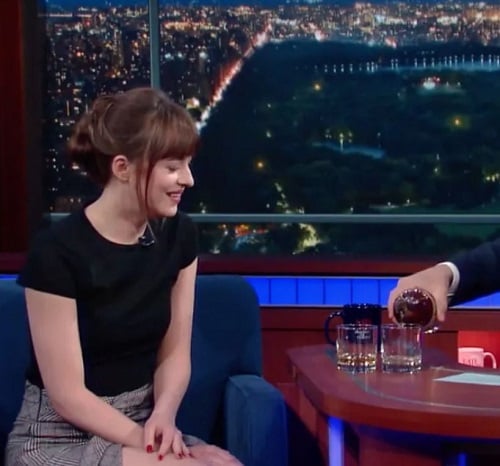 Dakota Johnson with a glass of alcohol