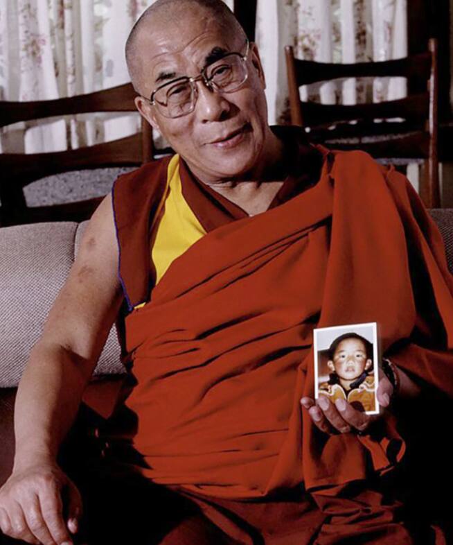 The Dalai Lama holding a picture of Gedhun Choekyi Nyima, the 11th Panchen Lama