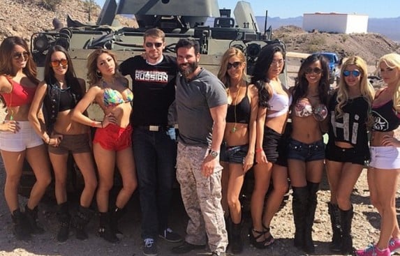 Dan Bilzerian posing with his models