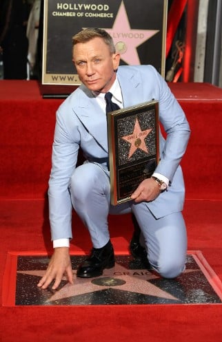 Daniel Craig posing with a star on the Hollywood Walk of Fame