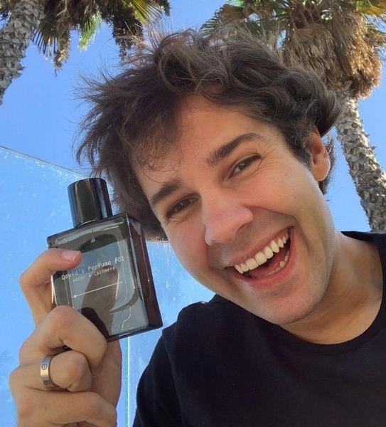 David Dobrik posing with his perfume 