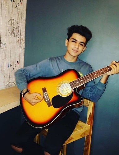 Devish Ahuja playing a guitar