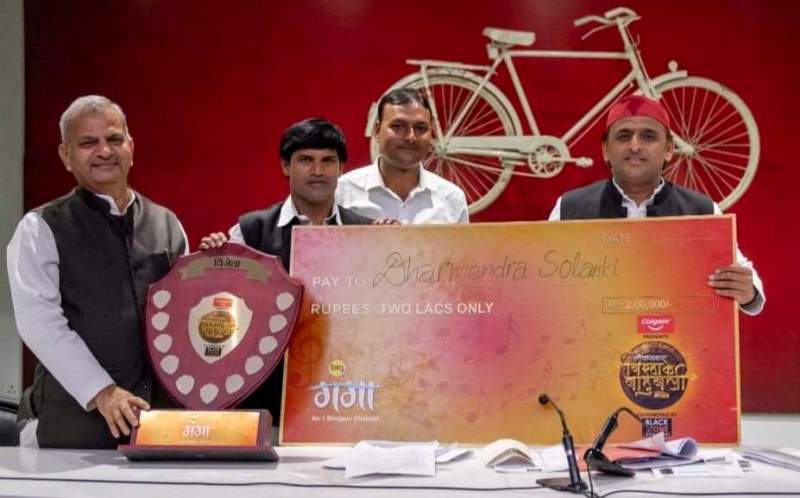 Dharmendra Solanki receiving a cheque of Rs. 2 lakh from Akhilesh Yadav after winning Biraha Mukabla on Big Ganga