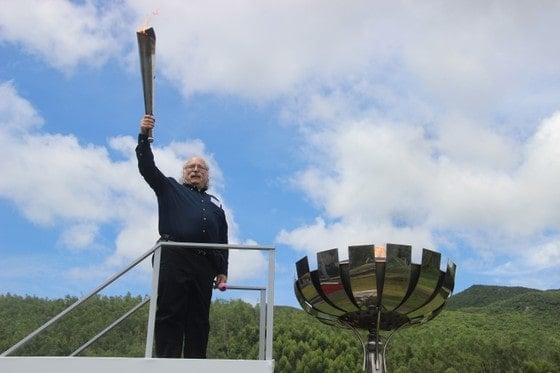 Duncan Haldane posing for a photo with the torch while inaugurating the first conference of the International Year of Basic Science