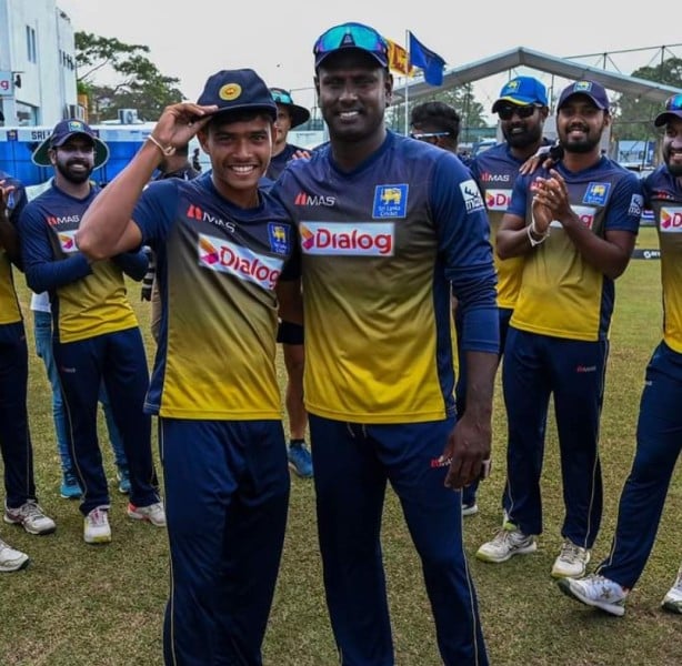 Dunith Wellalage being given his test cap by Angelo Mathews (right)