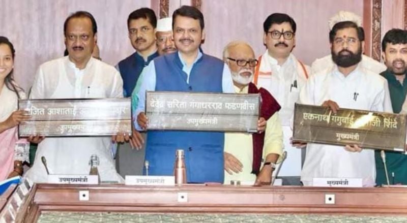 Eknath Shinde (right), Devendra Fadnavis (centre), and Ajit Pawar (left) showing their new nameplates