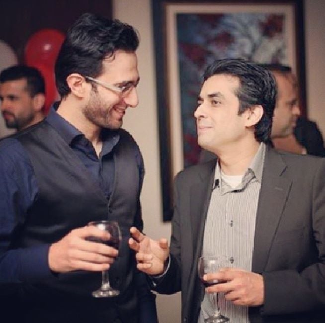 Emmad Irfani holding a glass of wine