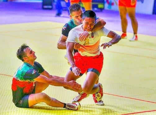 Fazel Atrachali (in green, holding the person from behind) during a match for Iran national team