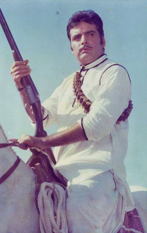Feroz Khan riding a horse with a rifle