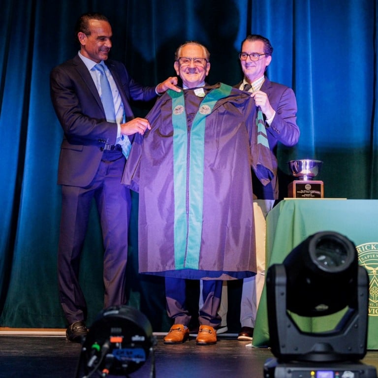 Frank Caprio receiving an honorary degree from his sons Frank T. and David at Bishop Hendricken High School