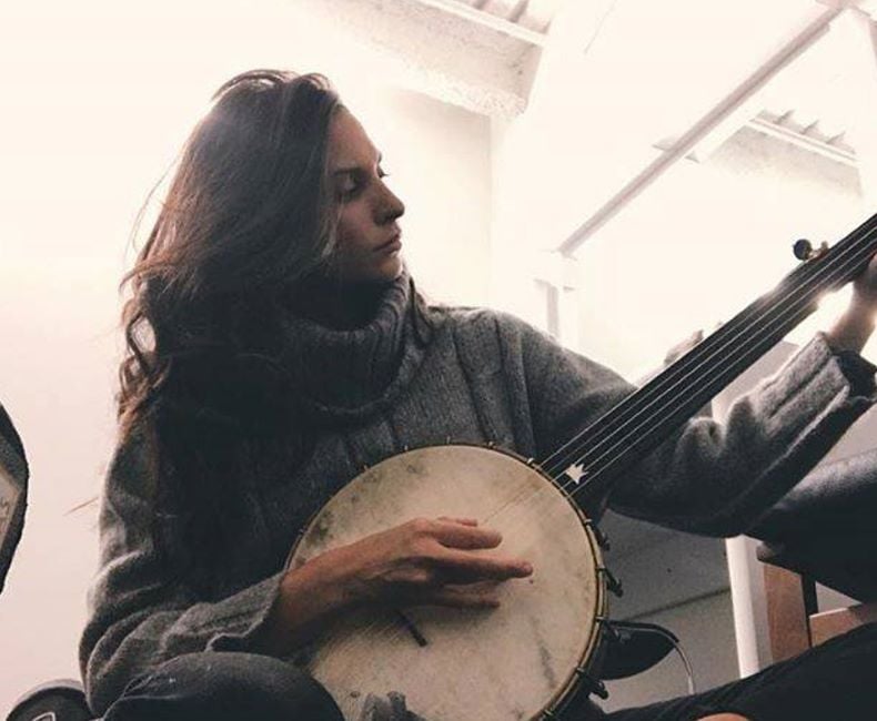 Genesis Rodriguez playing the banjo