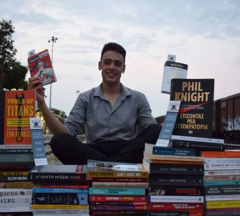 Giannis Lorenzo Kyrtsis posing with his book collection