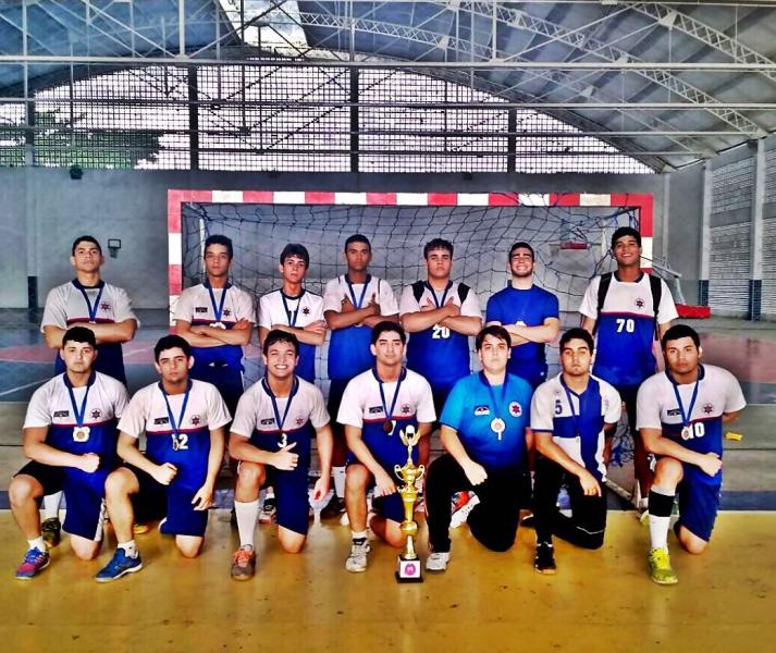 Guilherme Vilar (extreme right; standing), along with his handball team, after winning a match