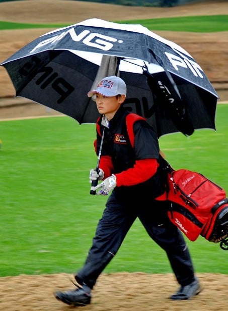 Haotong Li working as a caddie for his father when he was 12 years old