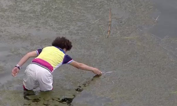 Haotong Li's mother while walking into the muddy water to get the broken club