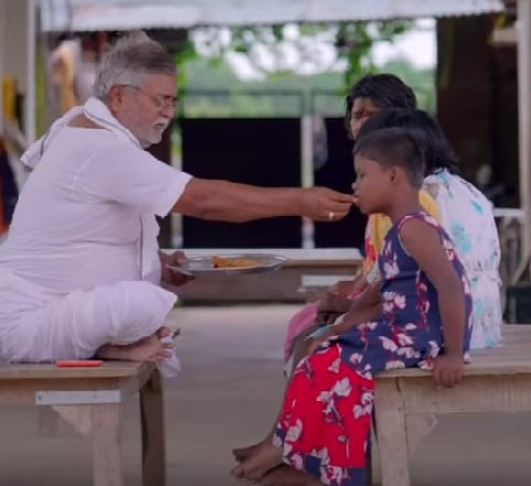 Hare Ram Pandey while feeding his adopted daughters