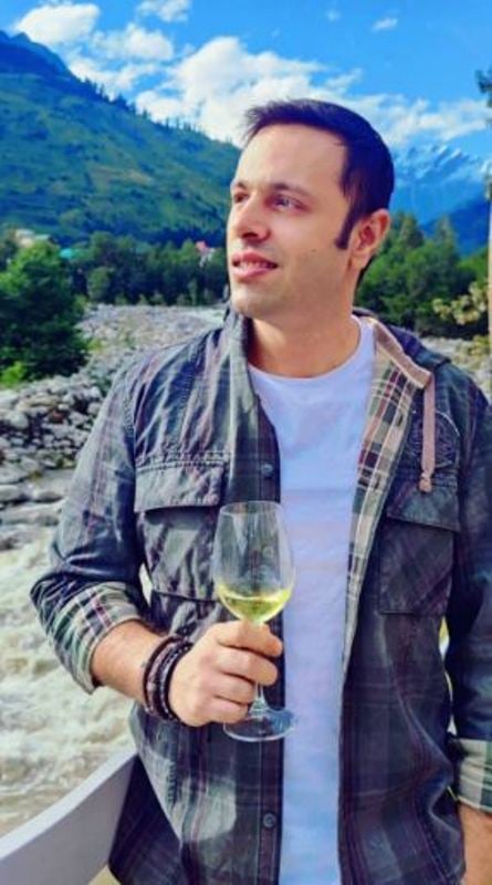 Harsh Tuli holding a glass of wine