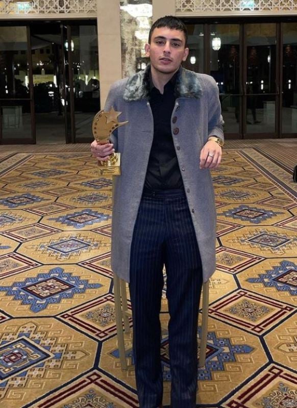 Hasan Raheem posing with the Breakthrough Artist of the Year award in 2021