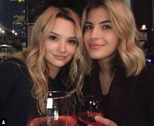 Hunter King holding a glass of wine