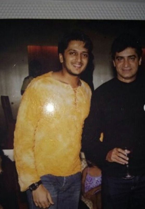 Indra Kumar (right) holding a glass of wine