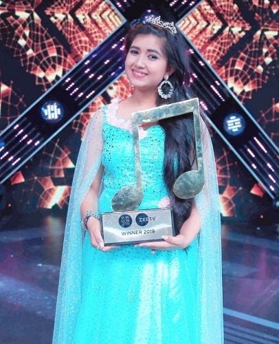 Ishita Vishwakarma holding Sa Re Ga Ma Pa 2018 winner trophy