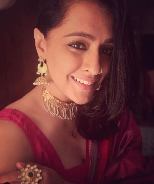 Ishita Yashvi while wearing bright color saree with statement jewellery