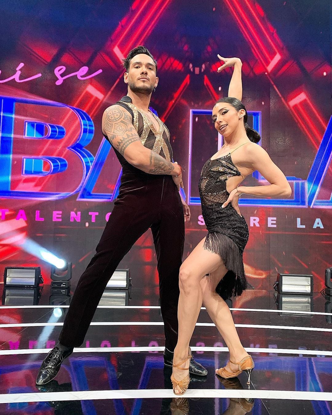 Iván Cabrera posing with her dance partner on the sets of the show Aquí se baila