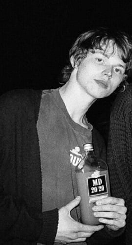 Jack Kilmer holding a bottle of alcohol