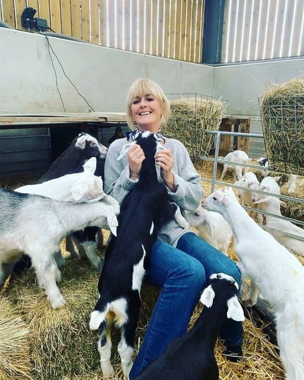 Jane Moore posing with baby goats