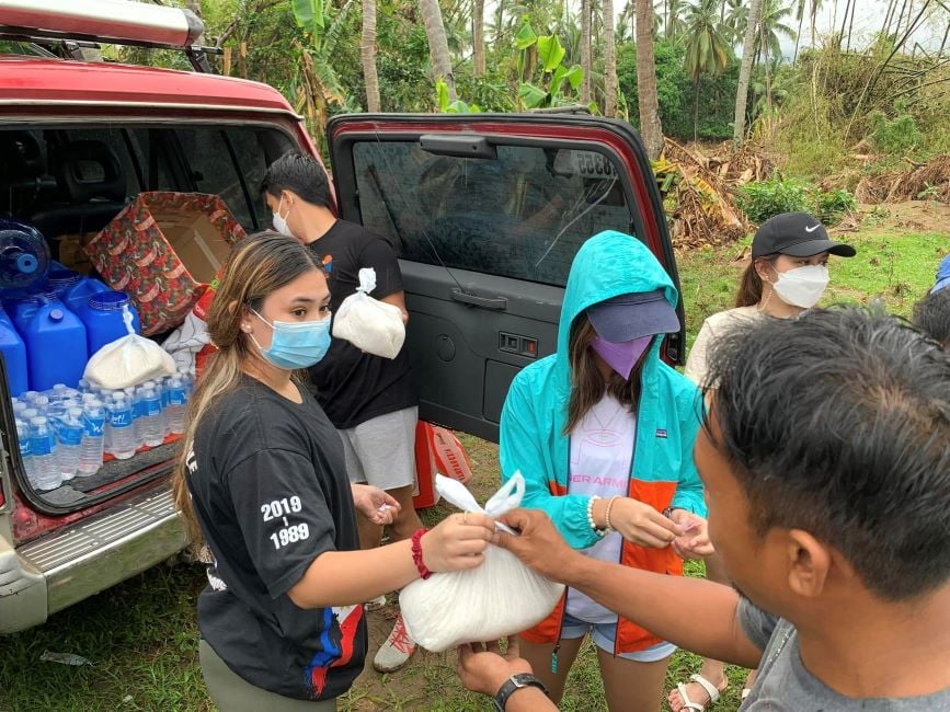Jas Dudley-Scales distributing food and supplies to people in Philippines
