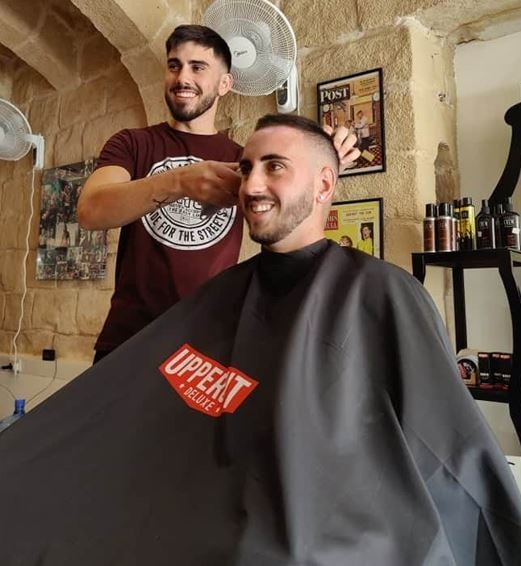 Jay Vella working at his barber shop