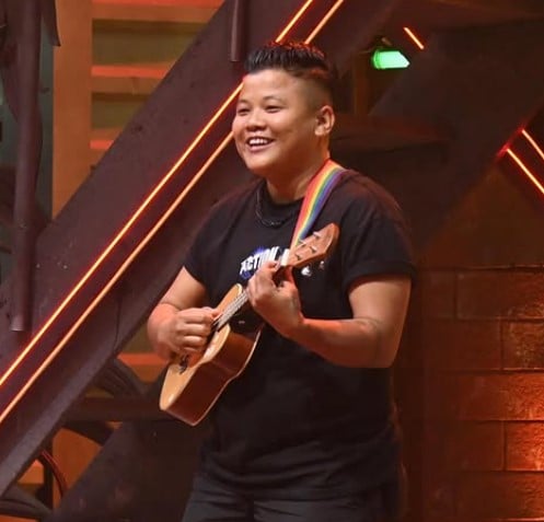 Jeanbi Gangmei playing a Ukulele while singing a song