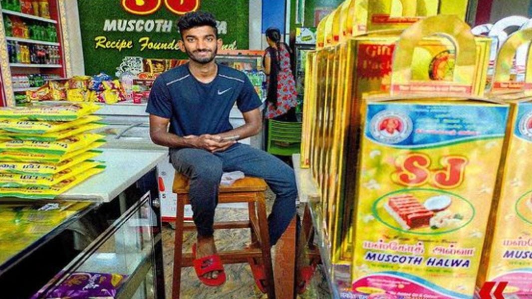 Jeswin Aldrin sitting at his Halwa store