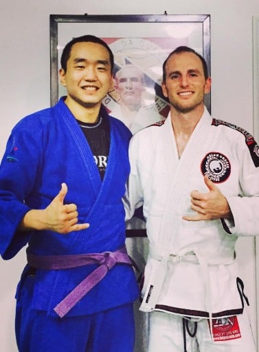 Joe Gebbia posing in Jiujitsu uniform with his trainer