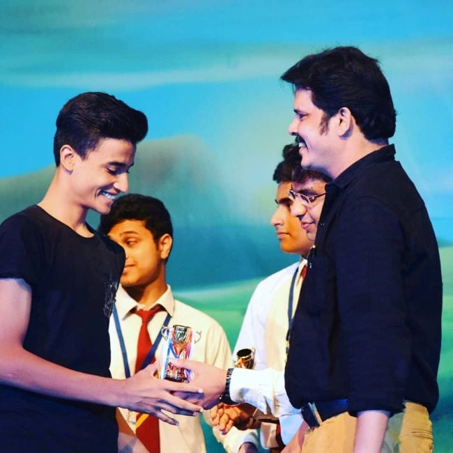 Joel Mathew receiving first prize in the Inter School Mime Competition from his father