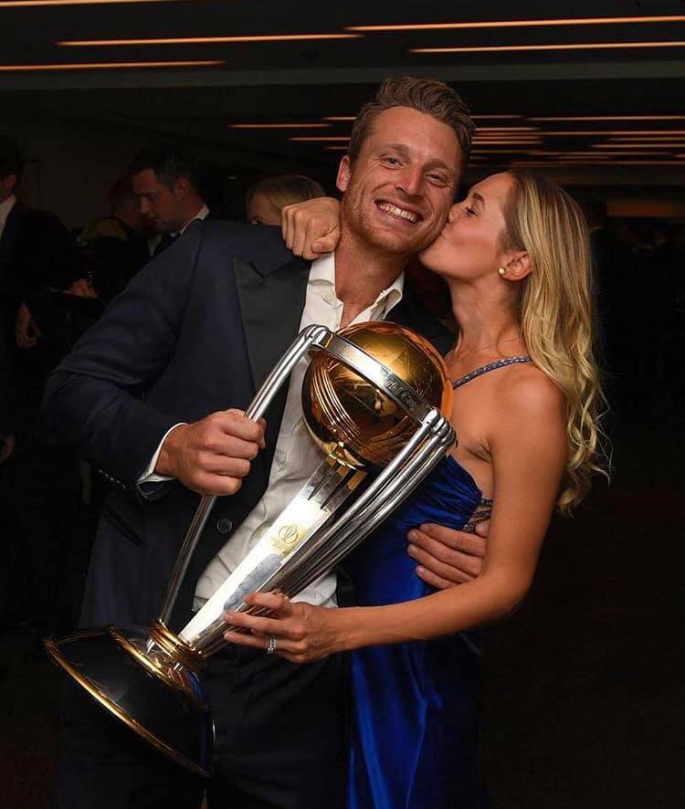 Jos Buttler holding the 2019 ODI World Cup Trophy while his wife kissing him