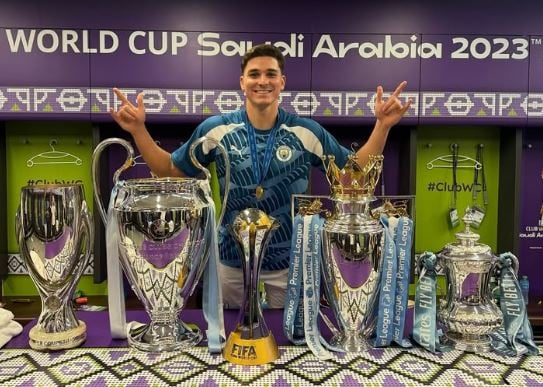 Julian Alvarez with the FIFA Club World Cup Trophies
