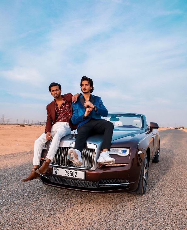 Junaid Malik posing with a car