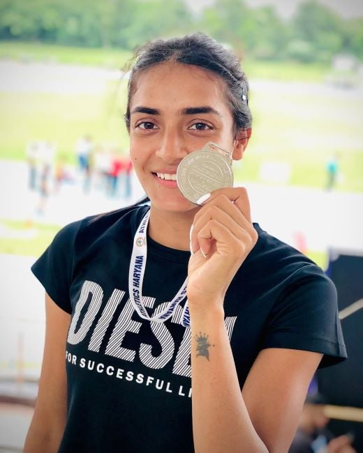 Kajal Jangra holding a silver medal won in a national level long jump competition