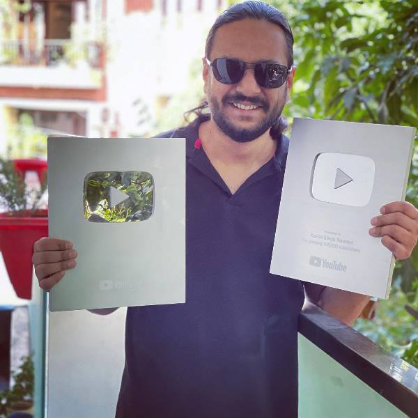 Karan Singh posing with his YouTube play buttons