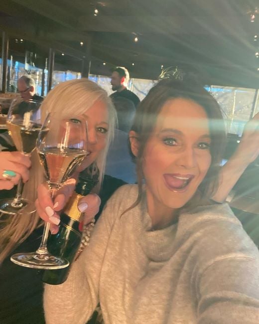 Kathy Sabine holding a glass and bottle of alcohol