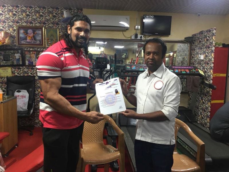 Ketan Karande receiving the felicitation certificate from the Humanity First Foundation