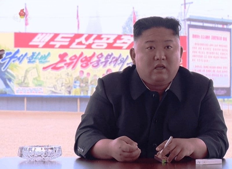 Kim Jong-un sitting with a cigarette in his hand during an event