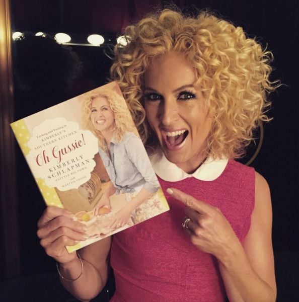 Kimberly Schlapman posing with her cookery book titled 