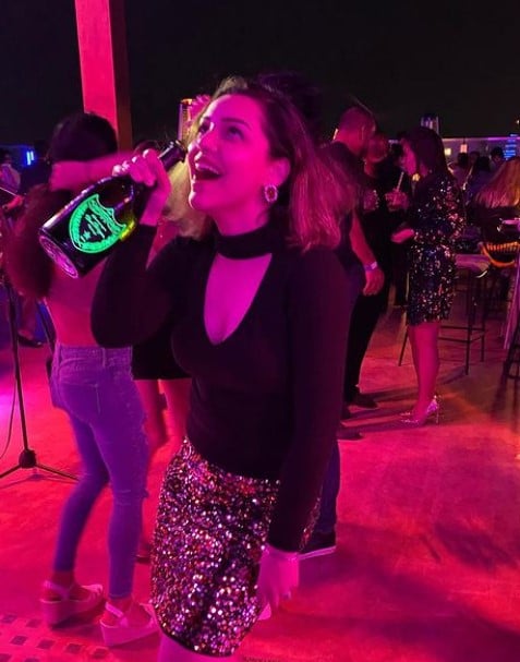 Kyra Dutt enjoying a bottle of alcohol