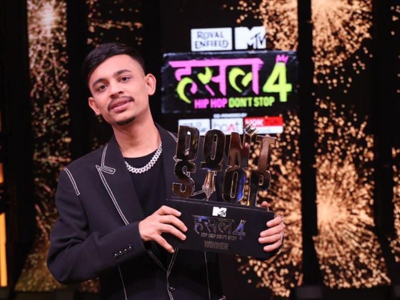 Lash Curry posing for a photo with his Hustle Season 4 trophy