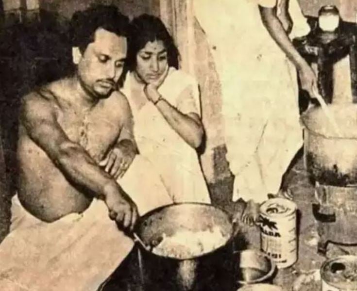Lata Mangeshkar (sitting) learning cooking skills from composer Anil Biswas