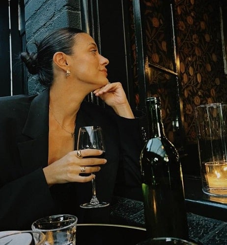 Laysla De Oliveira holding a glass of wine