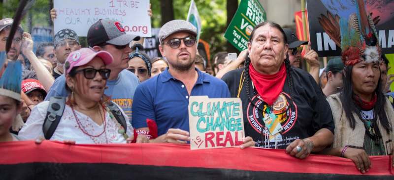 Leonardo DiCaprio holding a placard on Climate Change